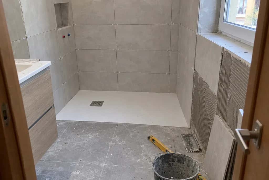 Plato de ducha a ras de suelo recién colocado en un baño todavía en obra