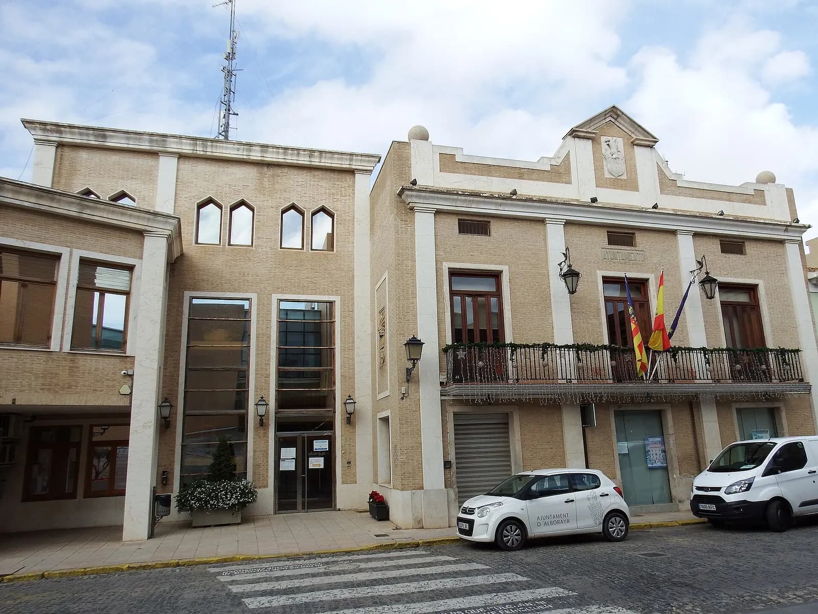 Fachada del Ayuntamiento de Alboraia/Alboraya, edificio de ladrillo claro con balcón y banderas