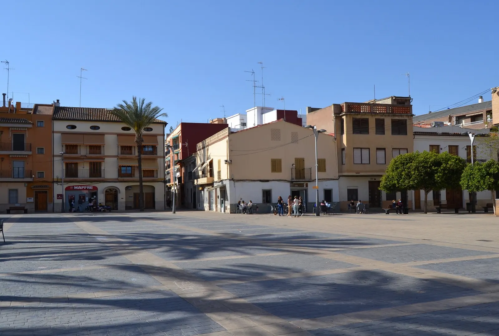 Plaça Major de Almàssera, con casas tradicionales de dos y tres plantas y una palmera
