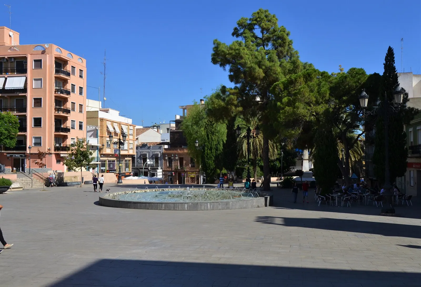 Plaça d'Emilio Castelar de Burjassot, con fuente circular, pinos y edificios de viviendas