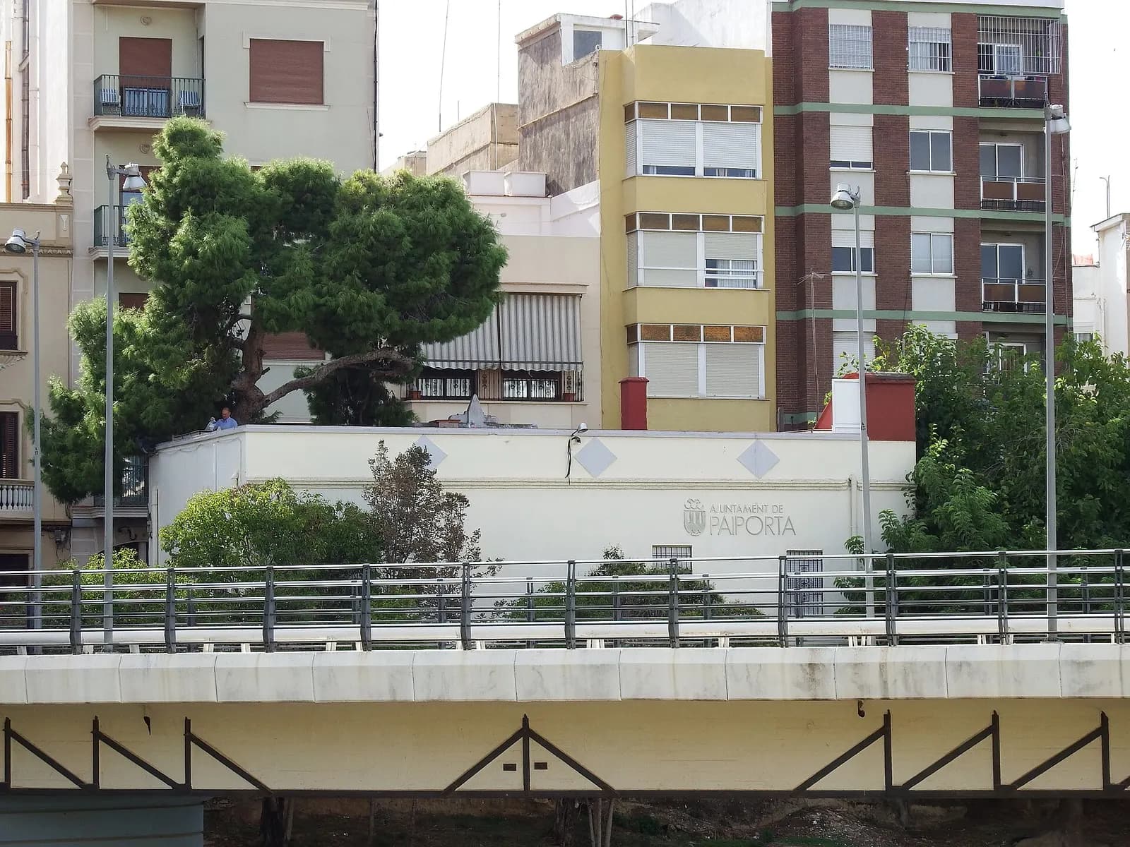Edificio del Ayuntamiento de Paiporta y bloques de viviendas junto al puente sobre el barranco