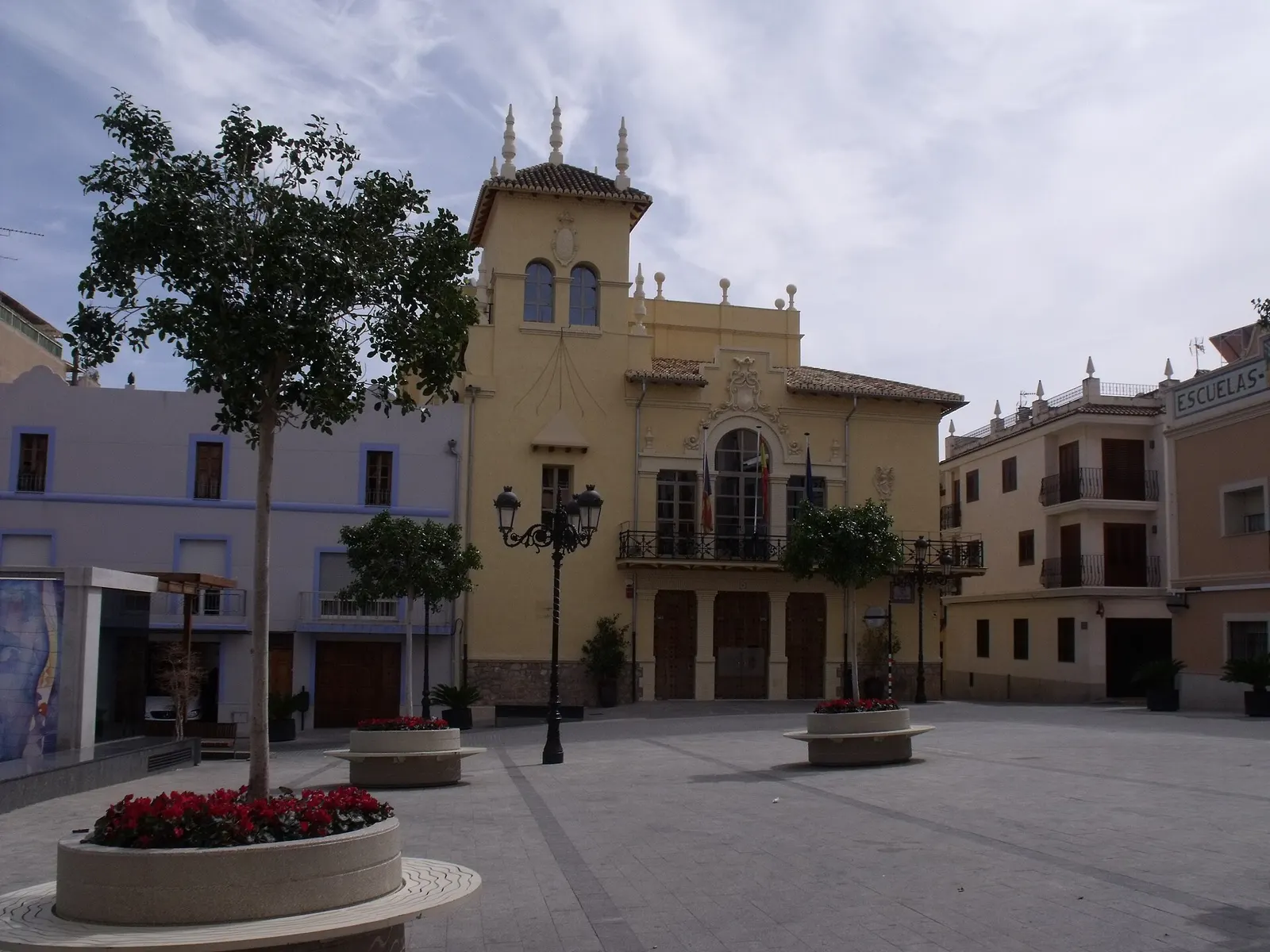 Plaza del Ayuntamiento de Riba-roja de Túria, con el edificio consistorial de torre y jardineras con flores