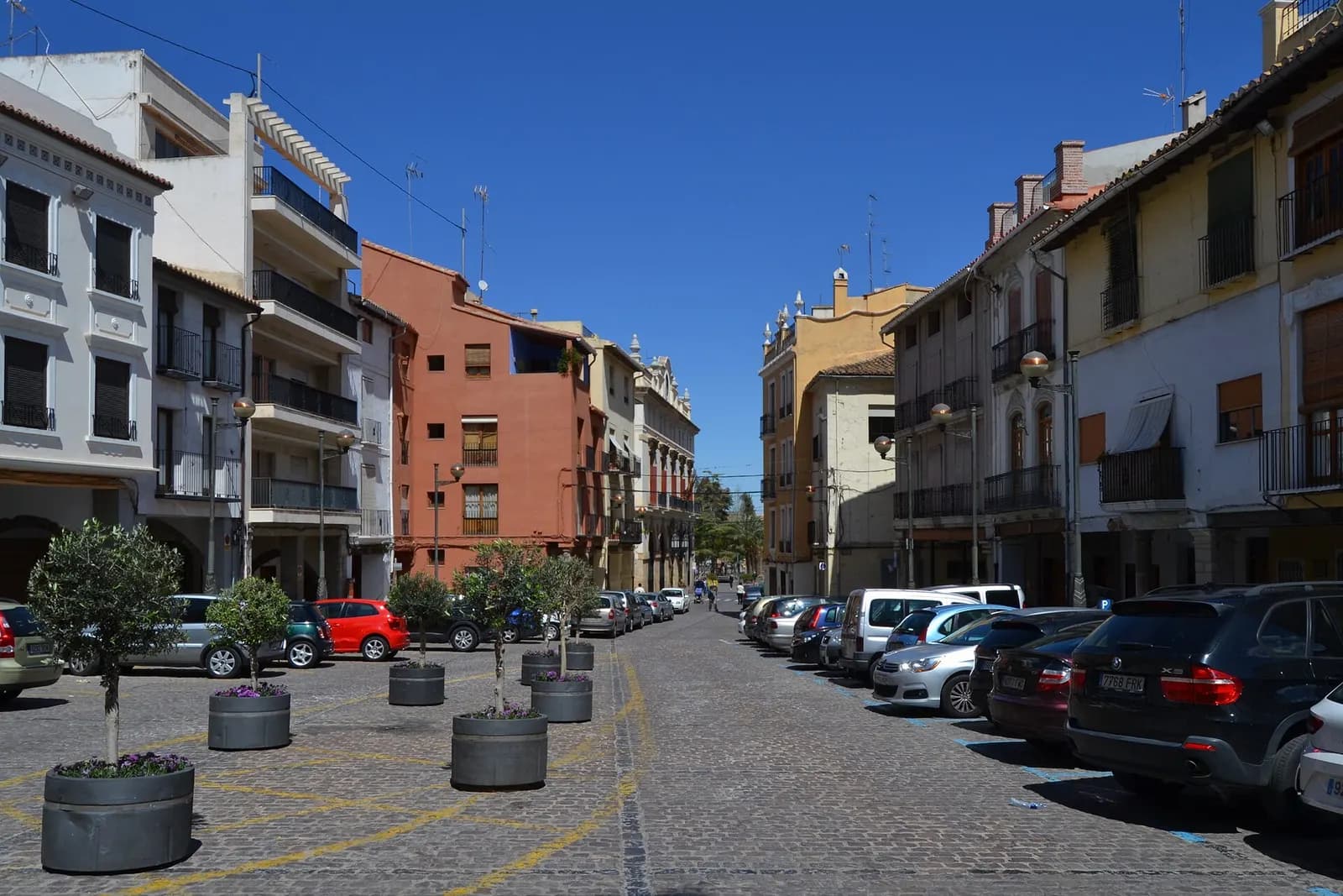 Plaça Major de Sagunt, calle empedrada con edificios de viviendas y coches aparcados